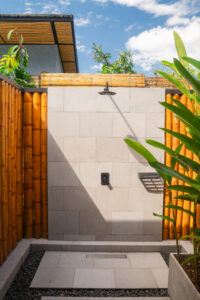 foto ducha exterior cabaña carpintero real con plantas y dia soleado